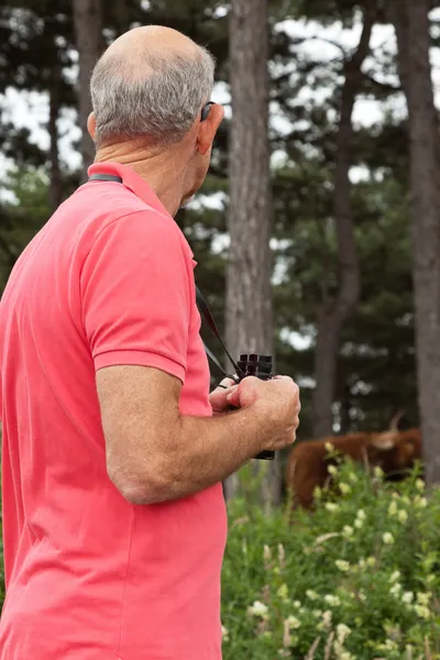 Äldre man med kikare utomhus. titta på scottish highland — Stockfoto