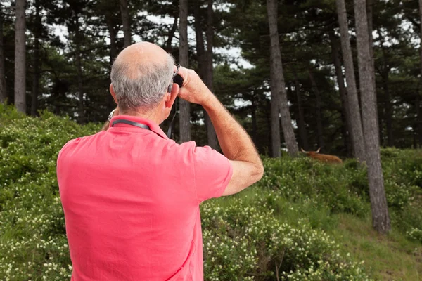Starší muž venku pomocí dalekohledu. sledování skotský highland — Stock fotografie