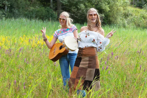 Due ragazze hippie anni '70 bionde retrò con occhiali da sole che fanno musica w — Foto Stock