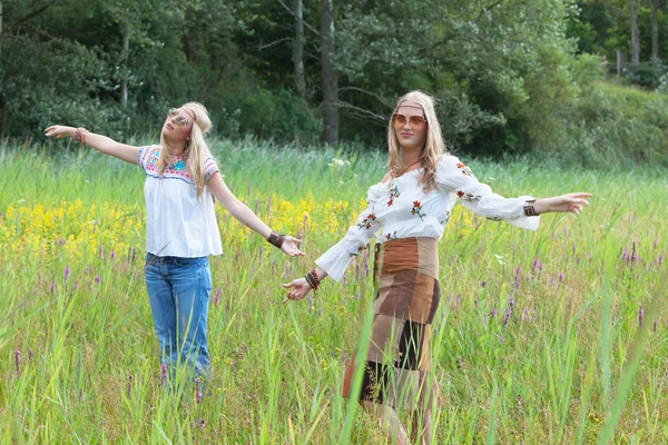 Zwei retro blonde 70er Jahre Hippie-Mädchen mit Sonnenbrille tanzen in f — Stockfoto