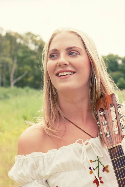 Retro bionda anni '70 hippie ragazza con chitarra acustica all'aperto in nat — Foto Stock