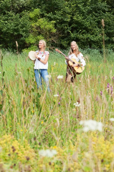 Twee retro blonde 70s hippie meisjes muziek maken met akoestische gui — Stockfoto