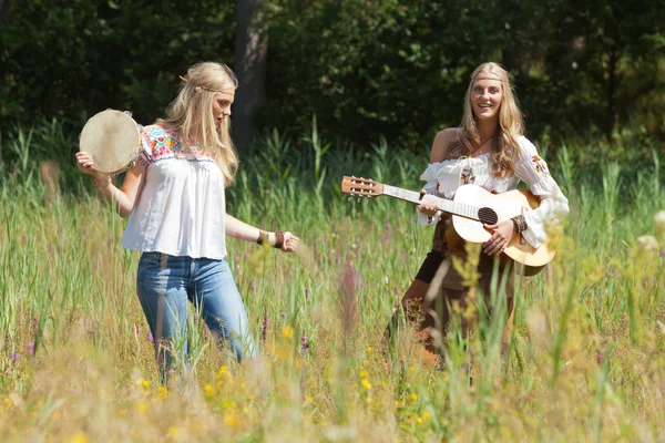 Deux filles hippies blondes rétro des années 70 faisant de la musique avec gui acoustique — Photo