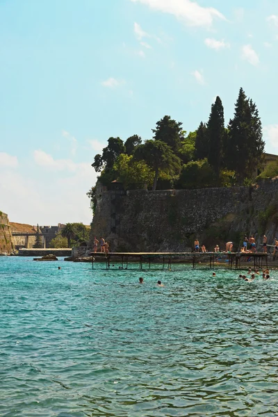 Menschen springen von Seebrücke ins Wasser am Hafen in der Nähe der alten Festung — Stockfoto