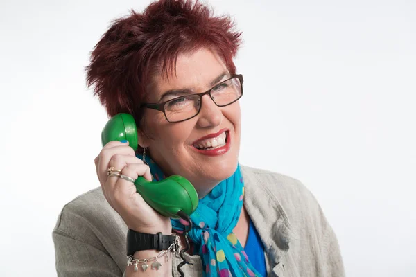 Middle aged woman calling with vintage green telephone. Red shor — Stock Photo, Image