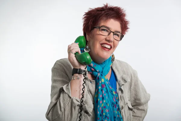 Middle aged woman calling with vintage green telephone. Red shor — Stock Photo, Image