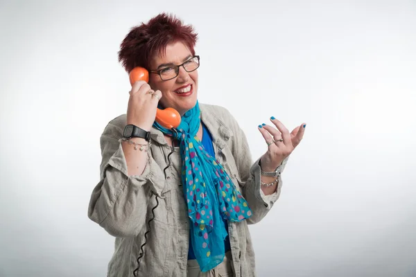 Femme d'âge moyen appelant avec un téléphone orange vintage. Sho rouge — Photo