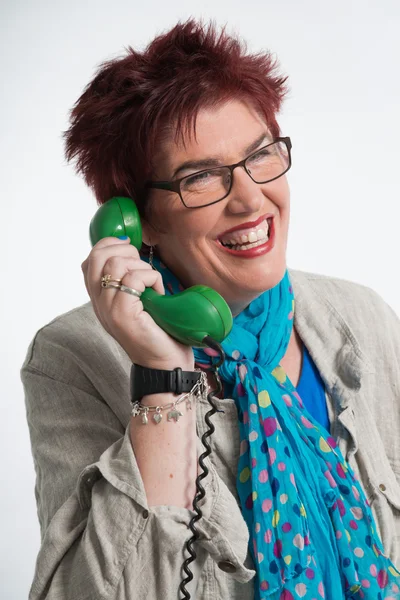 Donna di mezza eta 'che chiama con un telefono verde vintage. Shor rosso — Foto Stock