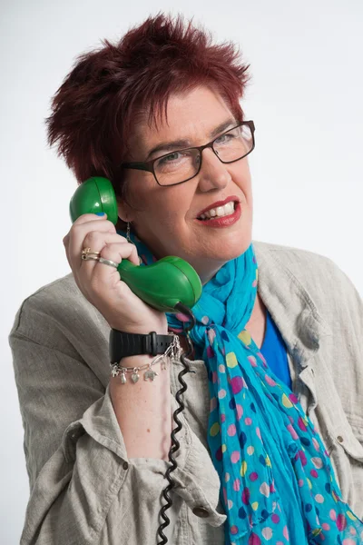 Donna di mezza eta 'che chiama con un telefono verde vintage. Shor rosso — Foto Stock