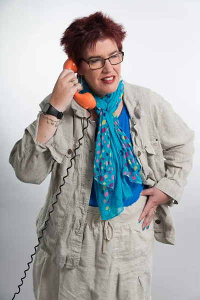 Mujer de mediana edad llamando con teléfono naranja vintage. Rojo sho — Foto de Stock