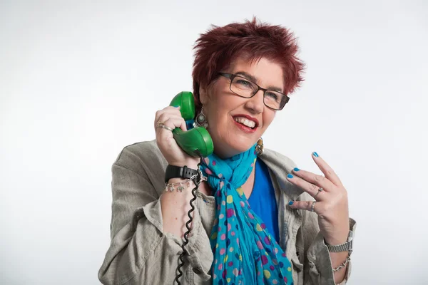 Middle aged woman calling with vintage green telephone. Red shor — Stock Photo, Image