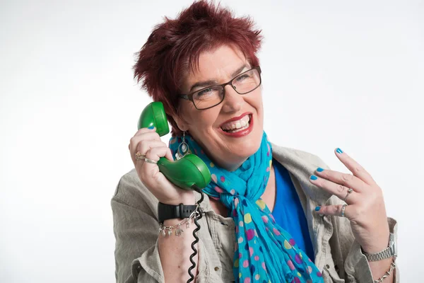 Middle aged woman calling with vintage green telephone. Red shor — Stock Photo, Image