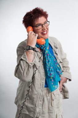 Orta yaşlı kadın Vintage turuncu telefonla arıyor. Kırmızı sho