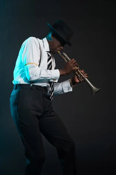 レトロなアフリカ系アメリカ人ジャズ音楽家彼のトランペットを演奏します。wea — ストック写真
