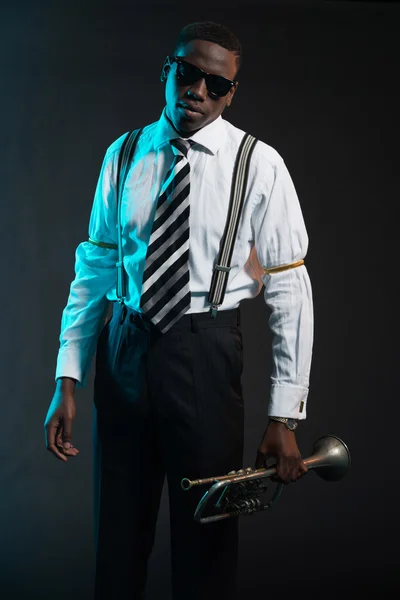 Retro african american jazz musician holding his trumpet. Wearin — Stock Photo, Image