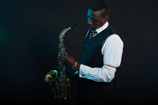 Американский джазовый музыкант-ретро-американец держит свой саксофон. Носить — стоковое фото