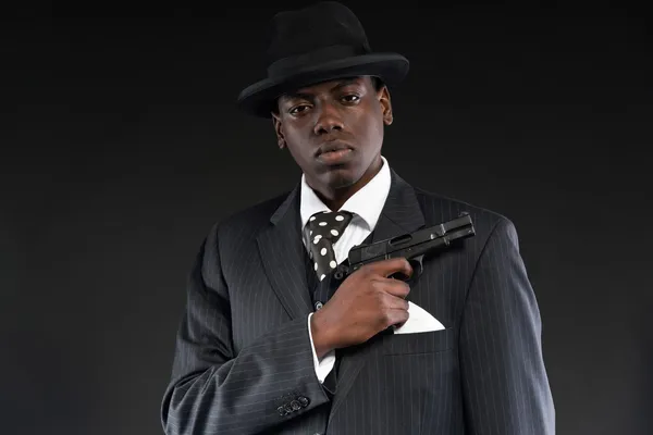 Hombre de la mafia afroamericana retro con traje a rayas y corbata un —  Fotos de Stock