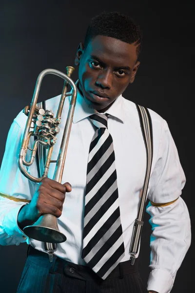 Retro afrikanska amerikanska jazzmusiker håller sin trumpet. wearin — Stockfoto