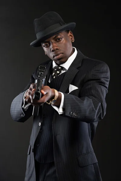 Retro afrikanska amerikanska maffian man klädd i randig kostym och slips en — Stockfoto