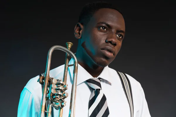 Retro afrikanska amerikanska jazzmusiker håller sin trumpet. wearin — Stockfoto