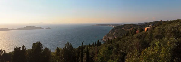 Panoramabild över havet i en vik med gröna berg och blå clo — Stockfoto