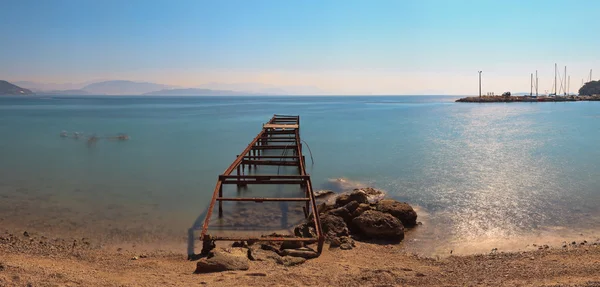 Panoramik çekim sahilde eski iskele. Mavi gökyüzü. uzun pozlama — Stok fotoğraf