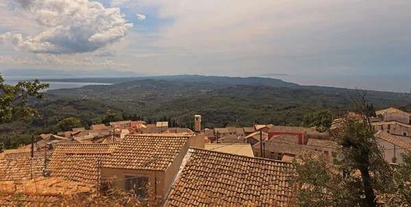 Paisaje panorámico de montaña verde con techos de casas en un sma —  Fotos de Stock