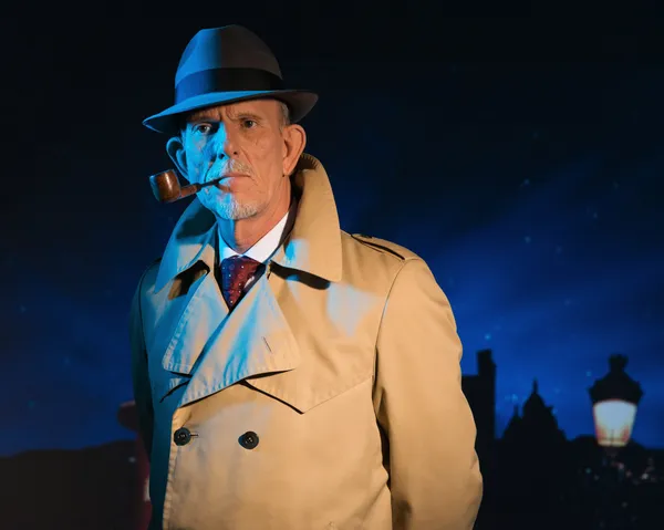 Retro detective man smoking pipe walking in city street at night — Stock Photo, Image