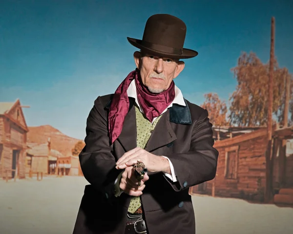 Senior homme occidental portant un chapeau brun et manteau tenant un revolv — Photo