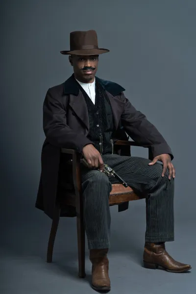 Retro afro człowiek kowboj zachodniej Ameryki z wąsem. siedzi — Zdjęcie stockowe