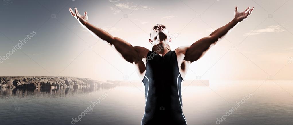 Muscled fitness triathlon athlete. Arms spread wide. Victory. St
