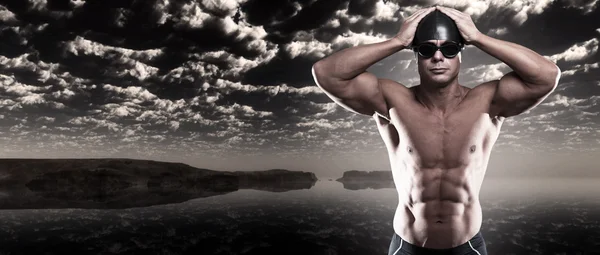 Umięśniony mężczyzna pływak z czapkę i okulary odkryty w wzburzonym morzu wi — Zdjęcie stockowe