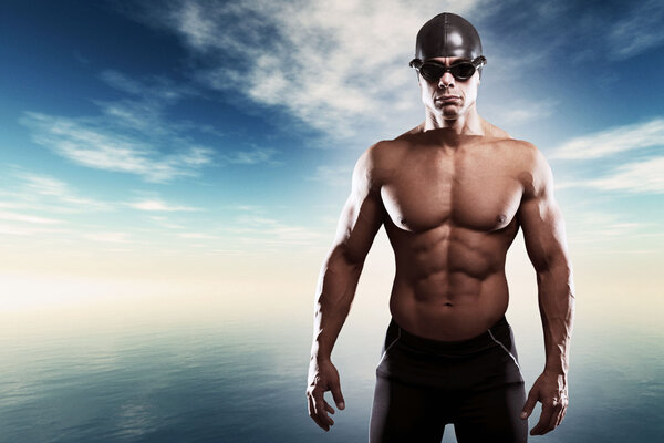 Muscled swimmer man with cap and glasses outdoor at a lake with