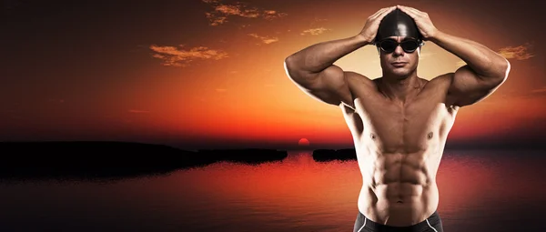 Hombre nadador musculoso con gorra y gafas al aire libre en un lago en su — Foto de Stock