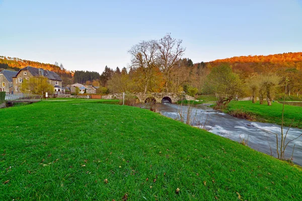 Paesaggio rurale con vecchio ponte sul fiume in streaming in autunno . — Foto Stock