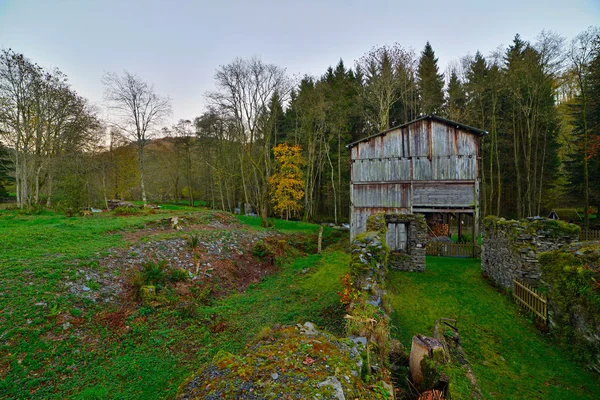 Old wooden shed in hill meadow landscape with autumn trees. Vres — Stock Photo, Image