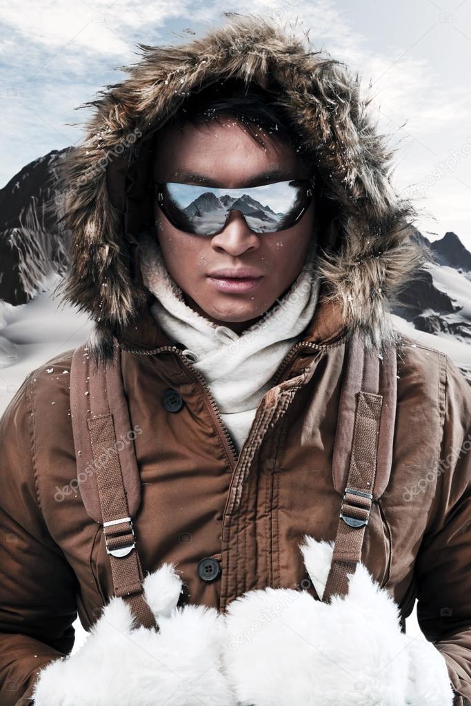 Asian winter sport fashion man with sunglasses and backpack in a