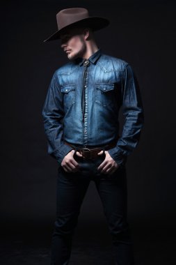 Modern moda kovboy. kahverengi şapka ve kot gömlek giyiyor. b