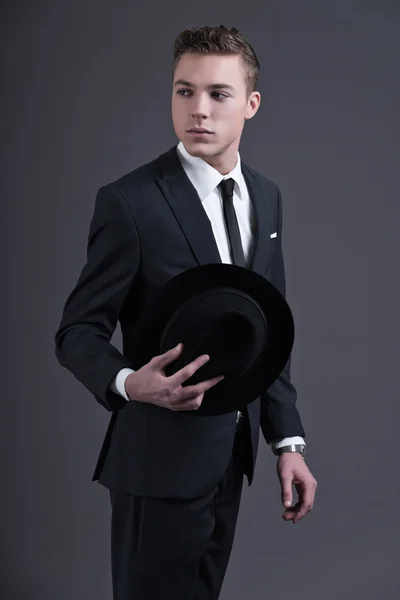 Retro moda ellili genç işadamı karanlık su giyiyor şapka ile — Stok fotoğraf
