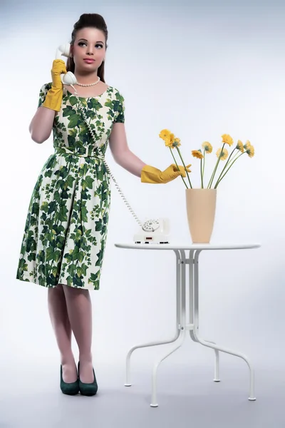 Retro 50s fashion housewife on the phone wearing yellow rubber g — Stock Photo, Image