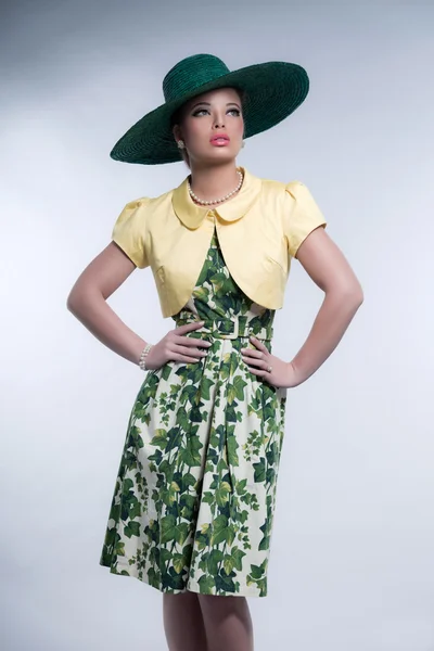 Retro 50s fashion brunette girl with hat wearing green dress and — Stock Photo, Image