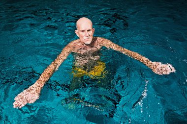 Kapalı Yüzme havuzunda sakallı sağlıklı aktif kıdemli biri. Biz