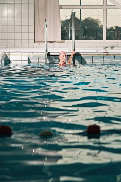 Sano uomo anziano attivo con barba in piscina coperta . — Foto Stock