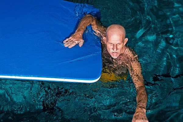 Homem idoso ativo saudável com barba na piscina interior pla — Fotografia de Stock