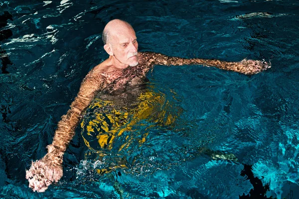 Здоровый пожилой человек с бородой в закрытом бассейне . — стоковое фото