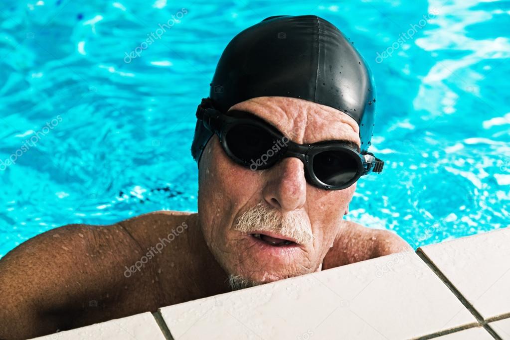 Active healthy senior man with beard in swimming pool wearing bl