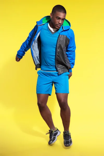 Jumping athletic black man in sportswear fashion. Runner with ho — Stock Photo, Image