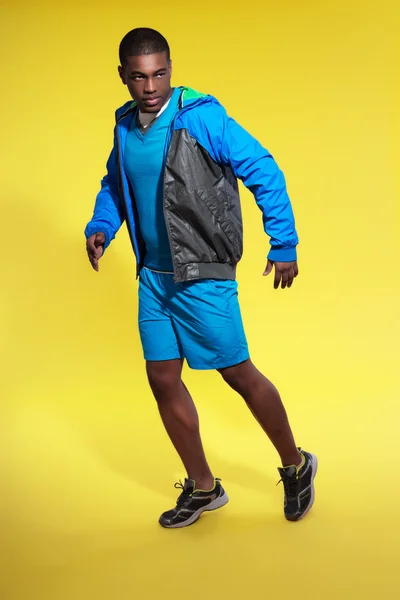 Hombre atlético negro en ropa deportiva. Corredor con chaqueta. En — Foto de Stock
