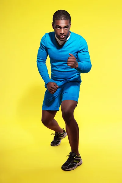 Atletische zwarte man in sportkleding mode. loper. intense kleuren — Stockfoto