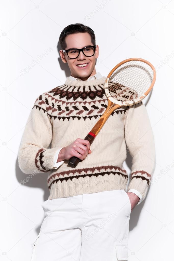Smiling retro tennis fashion man with black glasses holding a vi
